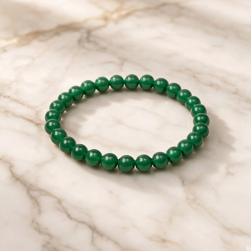 Shri Divya Ratan natural green jade beaded bracelet with 8mm round polished stones on a marble surface