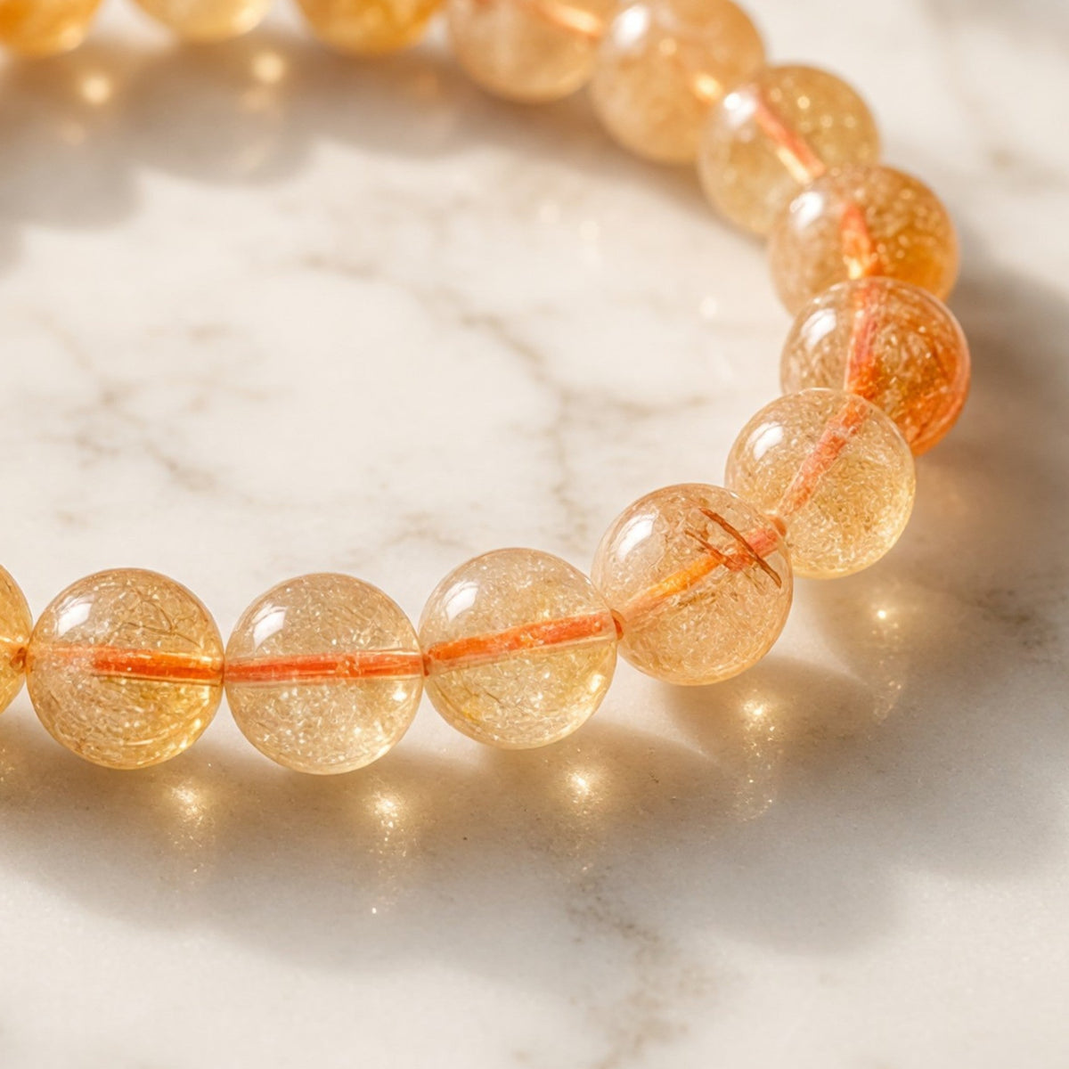 Shri Divya Ratan natural citrine crystal bead bracelet with 8mm round golden yellow stones on a marble surface