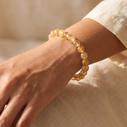 Shri Divya Ratan natural citrine crystal bead bracelet on a wrist, featuring 8mm golden yellow round beads.