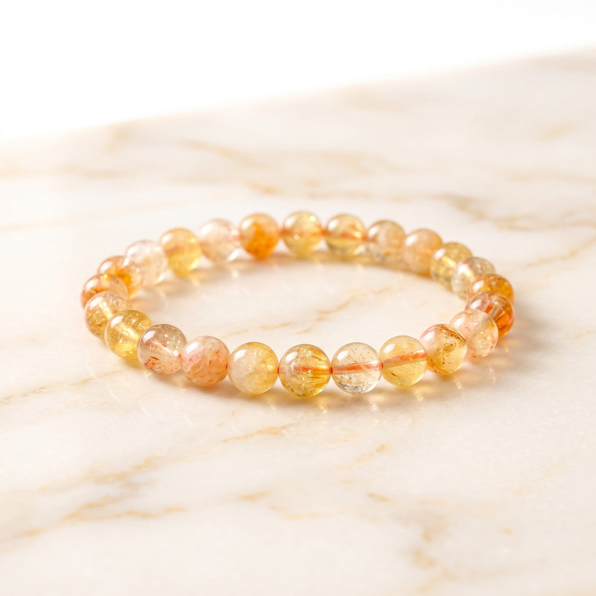 Shri Divya Ratan natural citrine crystal bead bracelet with warm yellow and amber tones on a marble surface.