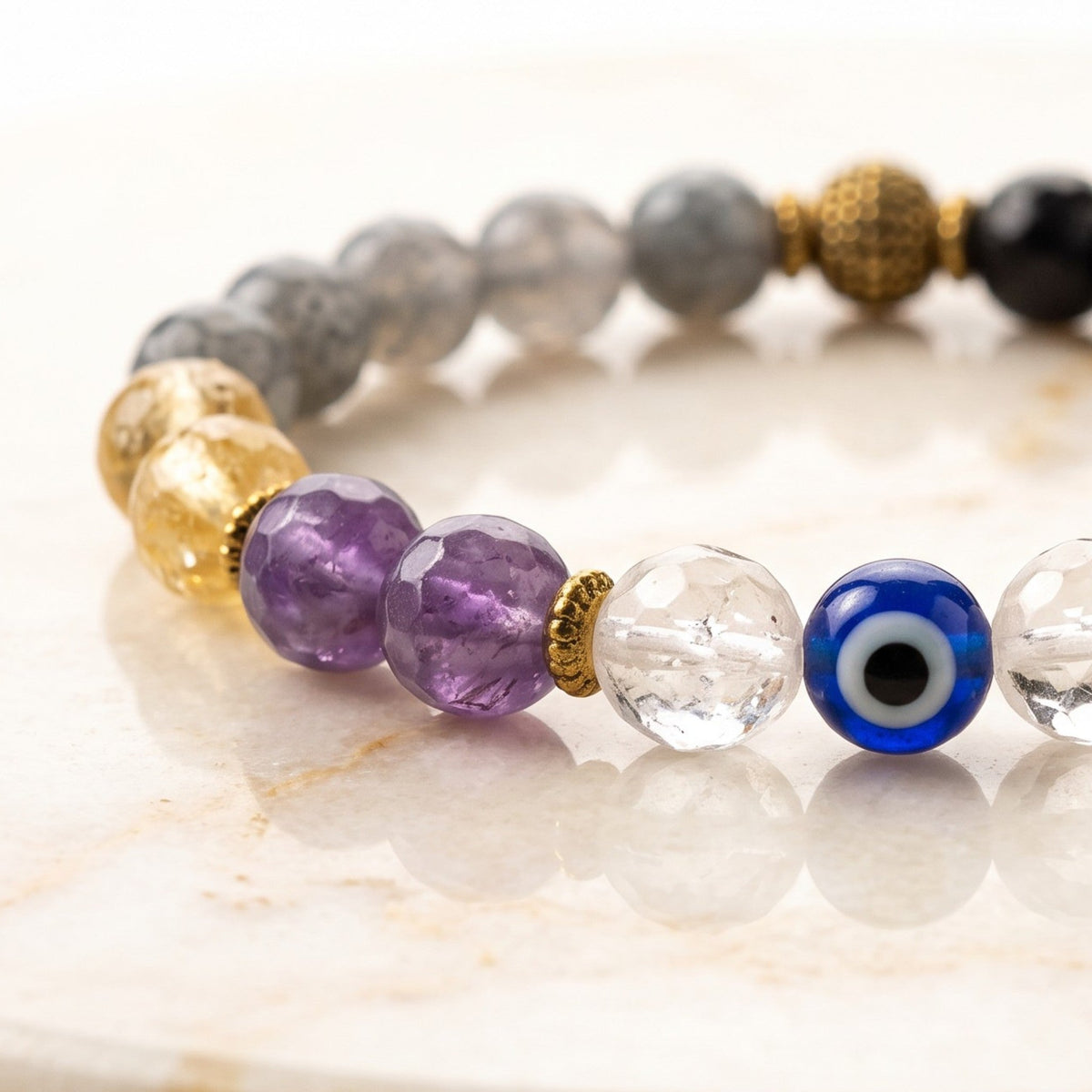 Shri Divya Ratan Nazar protection bracelet featuring 8mm diamond-cut crystals and a blue evil eye bead on a marble base
